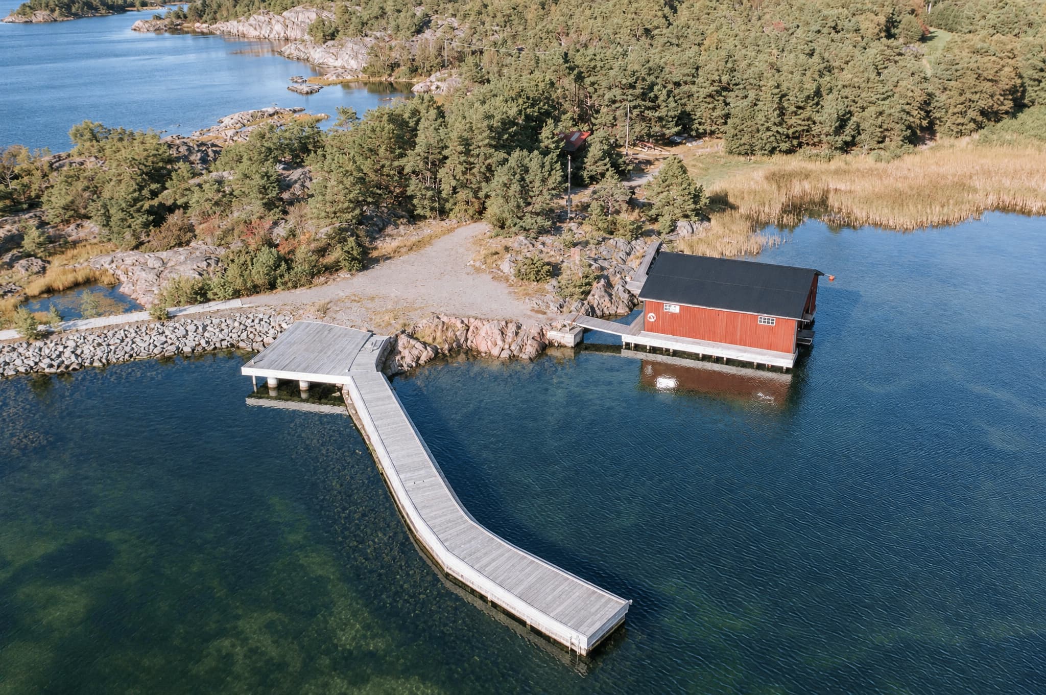 Flygbild över bryggan och den röda sjöboden på Fjärdlång
